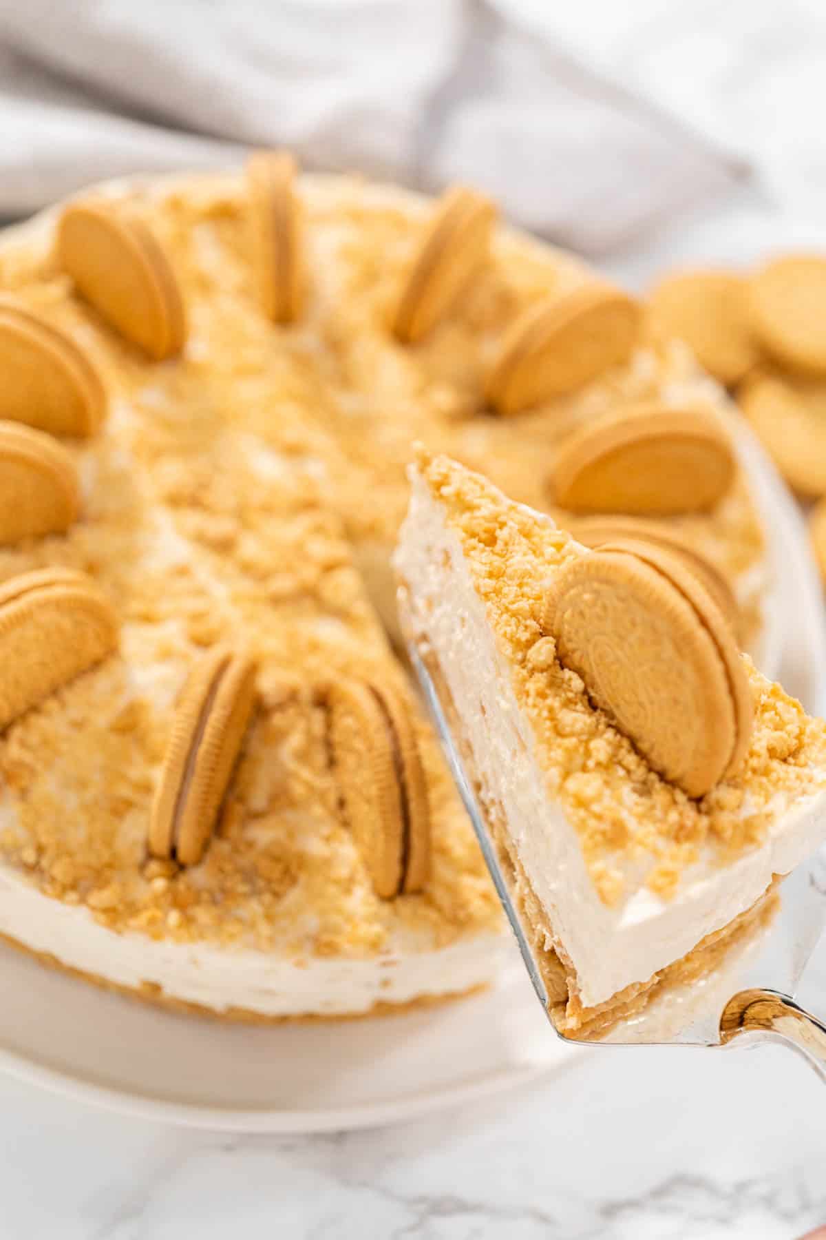 A slice of Golden Oreo Cheesecake being cut.