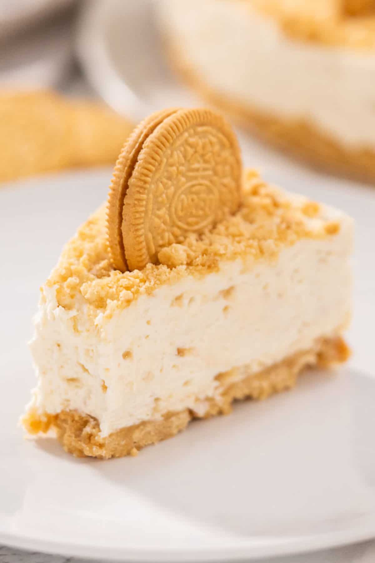 A slice of Golden Oreo Cheesecake with a bite taken out.
