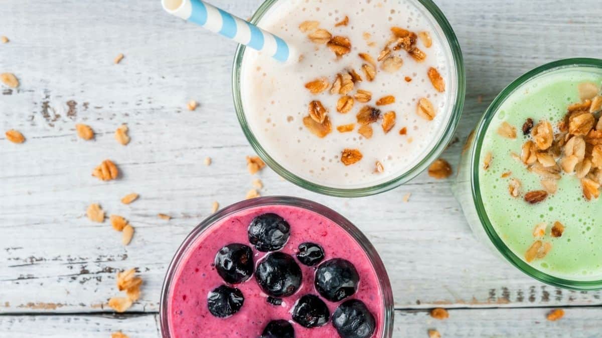 Three colorful smoothies on a table, an exampe of foods to nourish you while you may have low appetite due to anxiety.