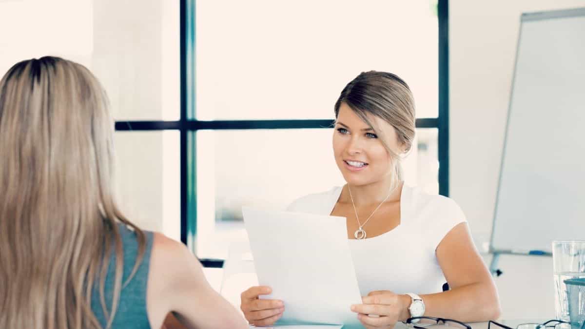 a woman sitting across the table from a woman interviewer for a job interviewer, an example of how being overweight as a woman can impact your career because of diet culture.