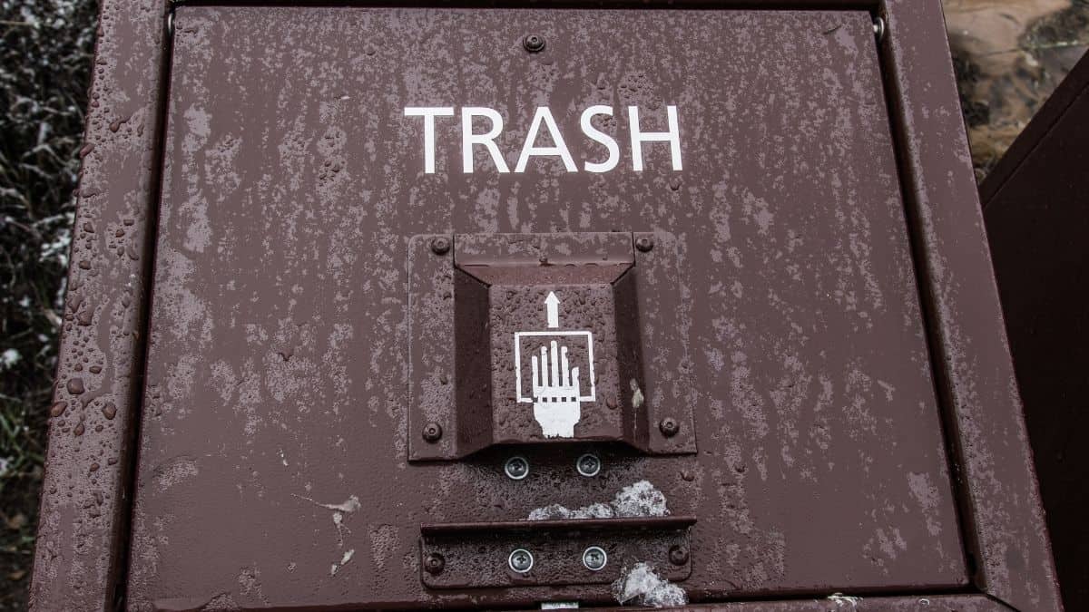 a brown trash can with the word trash spelled out.