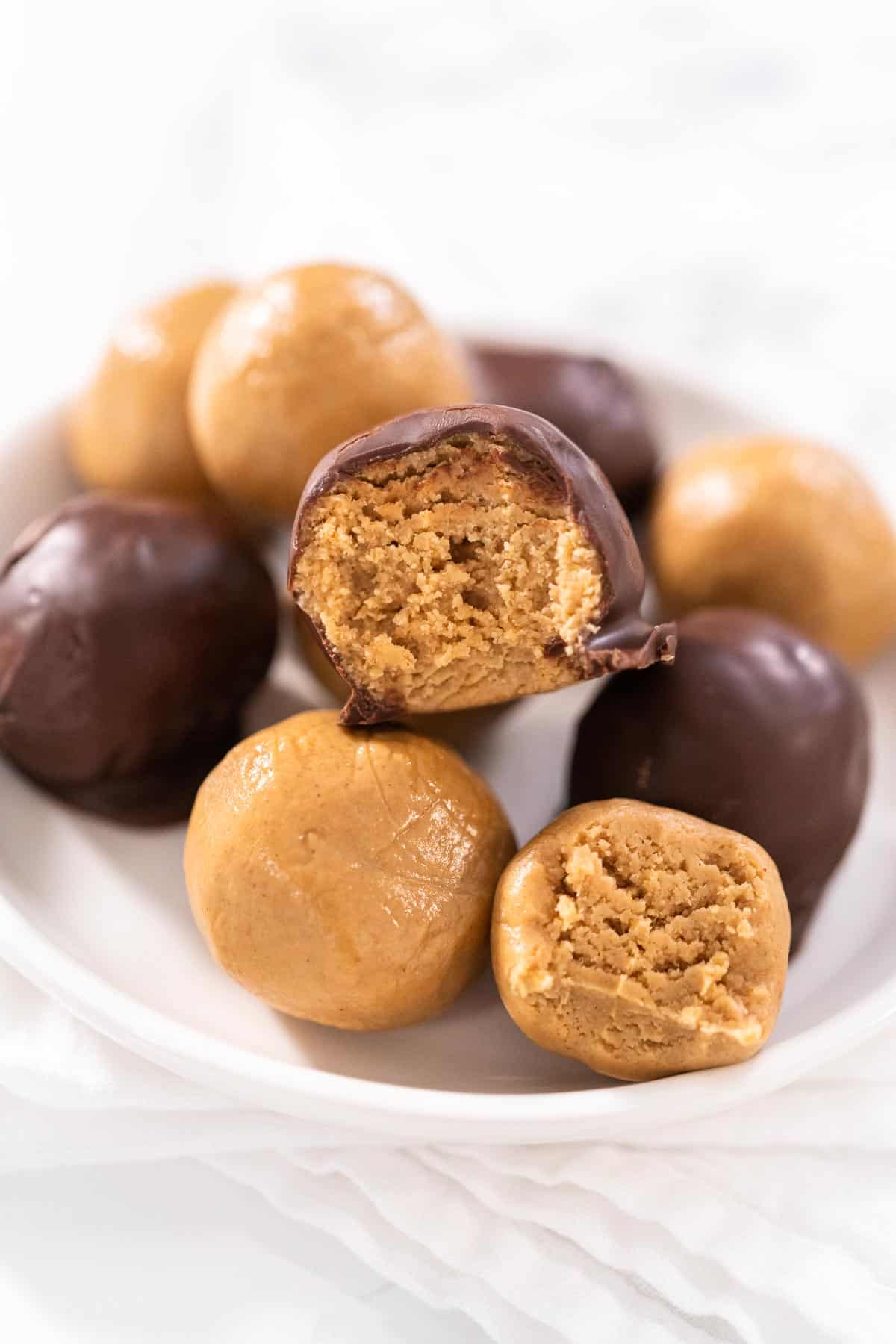 A mixture of peanut butter balls, some covered in chocolate.