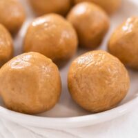 Close up of peanut butter bals on a white plate.