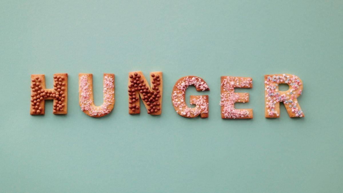The word hunger spelled out on a green background, you may not be able to stop eating even though you aren't physically hungry.