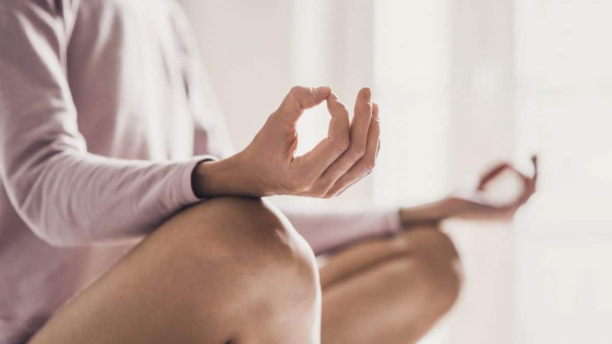 a woman peacefully sitting doing yoga, managing stress is a way to increase fertility.