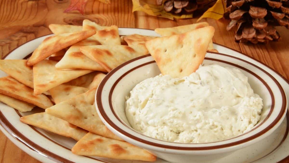 A bowl of dip with pita points ready to scoop it up, this may be an appetizer over the holidays.