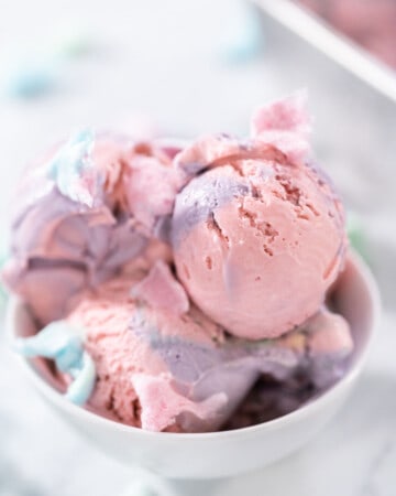 A bowl of pink and purple no churn cotton candy ice cream.