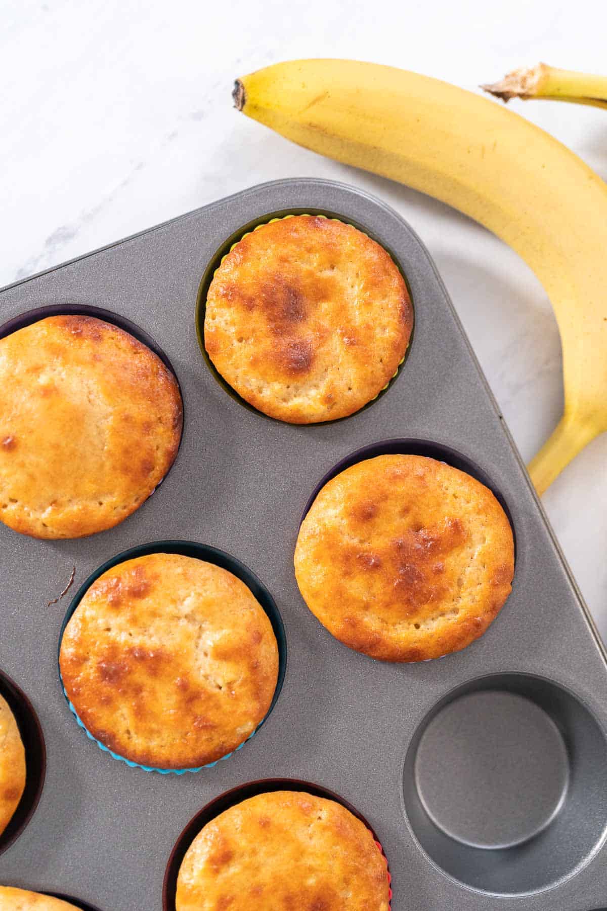 Banana protein muffins in a metal pan.
