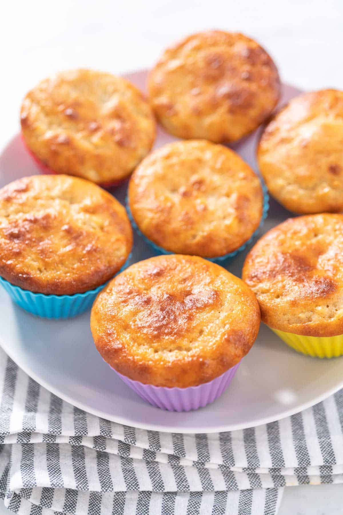 A plate of muffins resting on a lined kitchen towel.