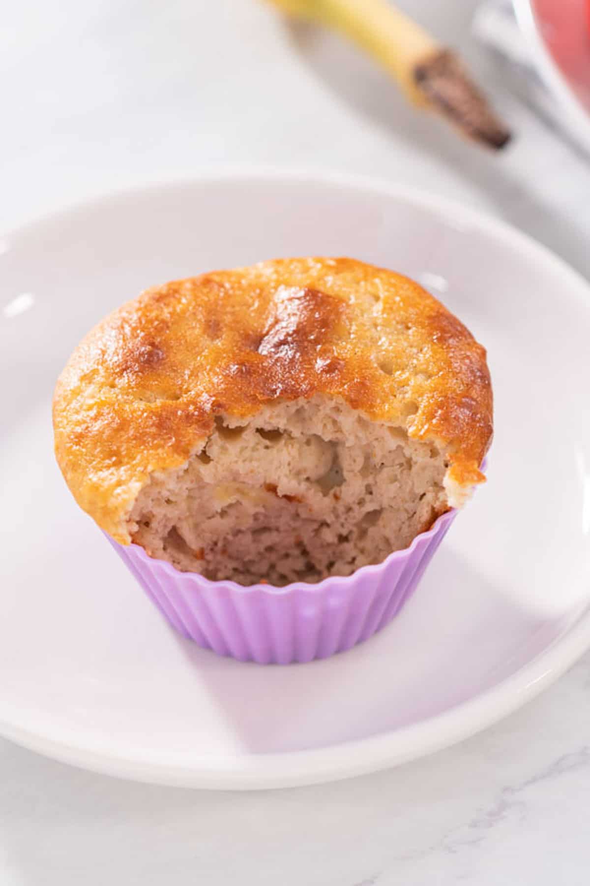 A muffin inside of a silicone liner, with a portion removed.