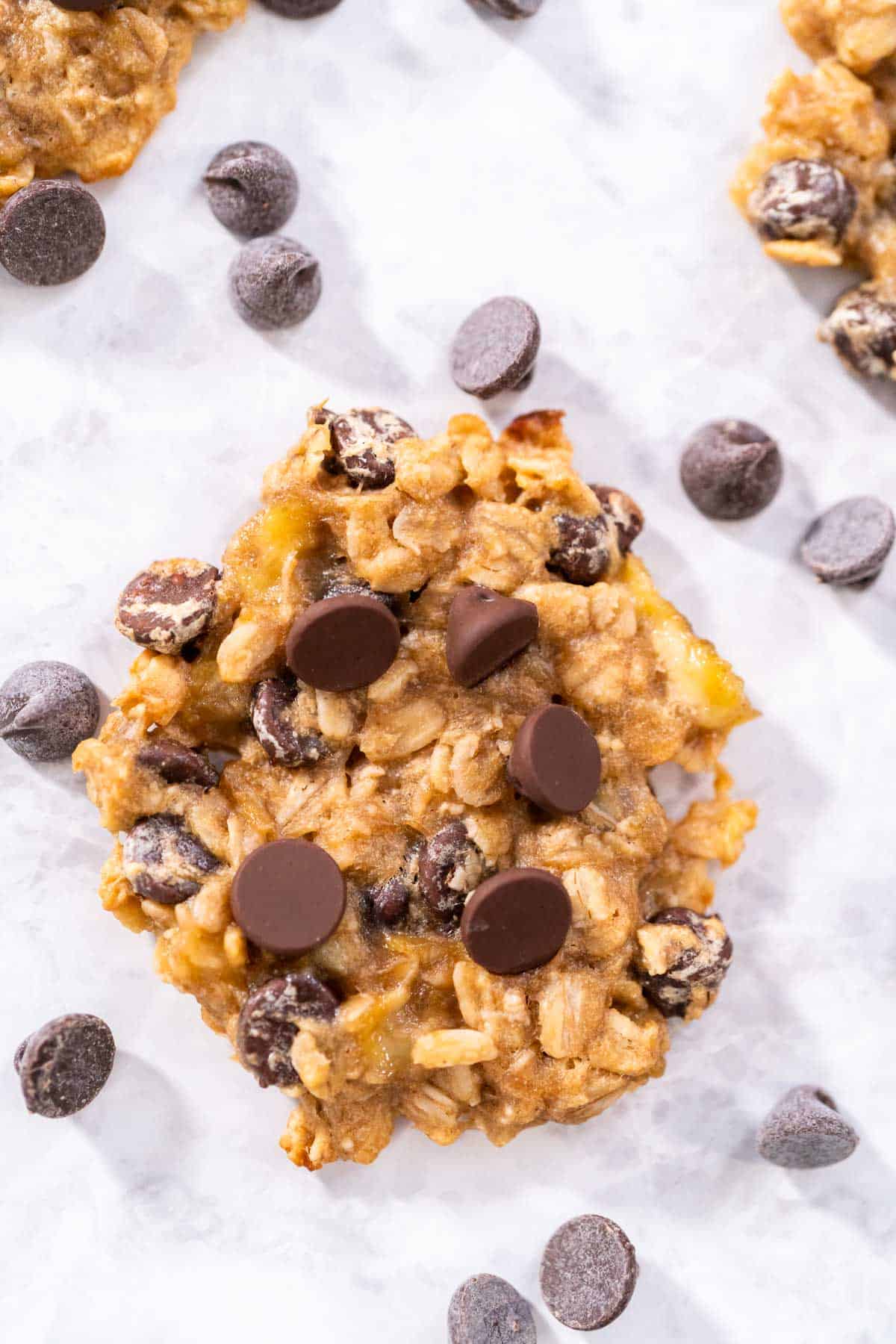 Overhead shot of 3 ingredient banana oatmeal cookies with chocolate chips sprinkled arround.