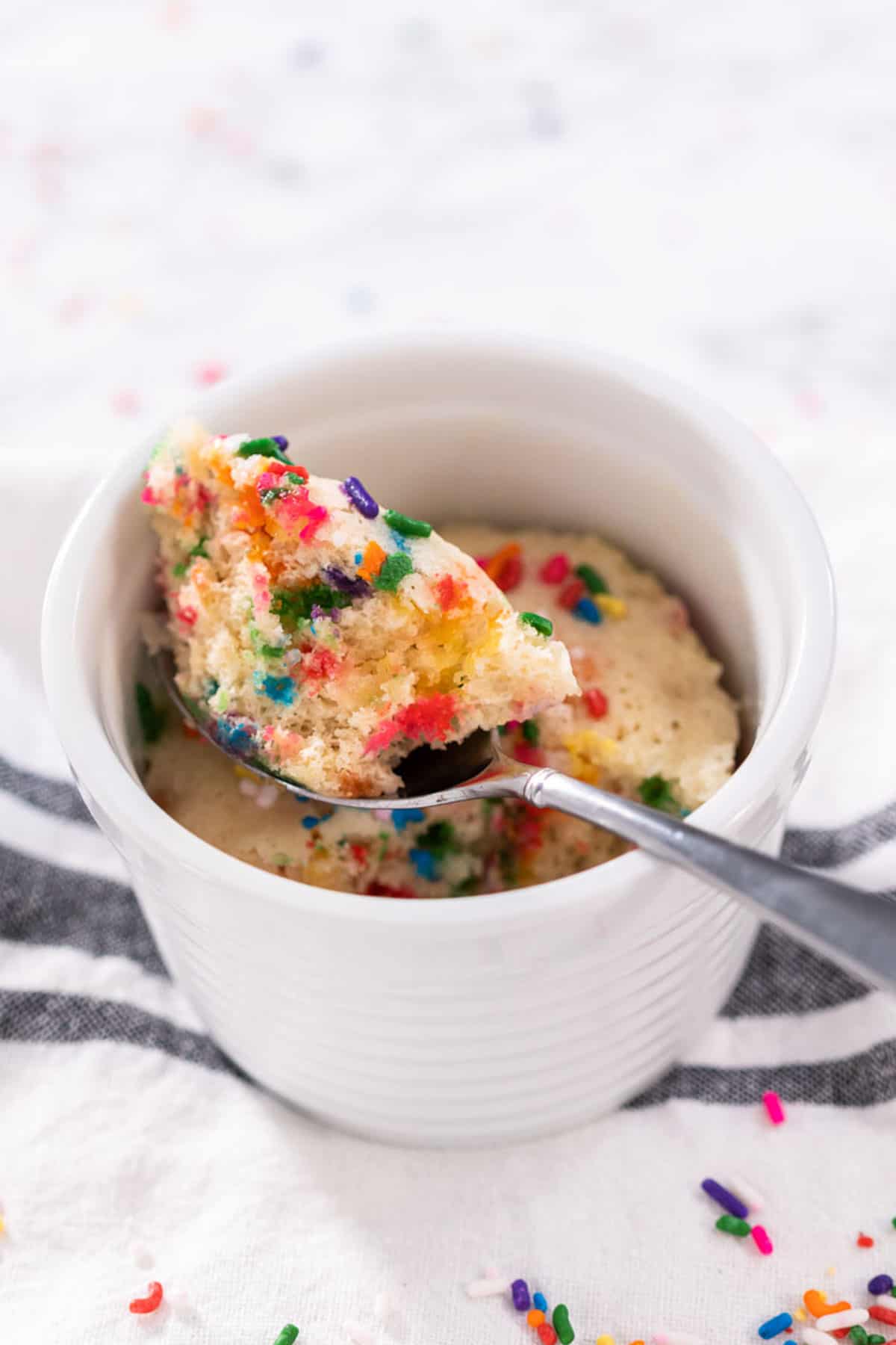 vanilla vegan mug cake with a spoon.