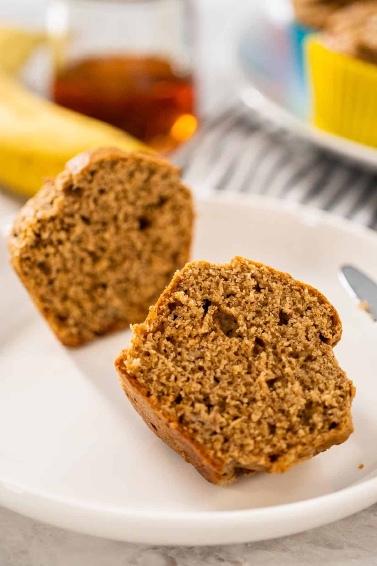 A sliced open Almond Flour Banana Muffin on a white plate.