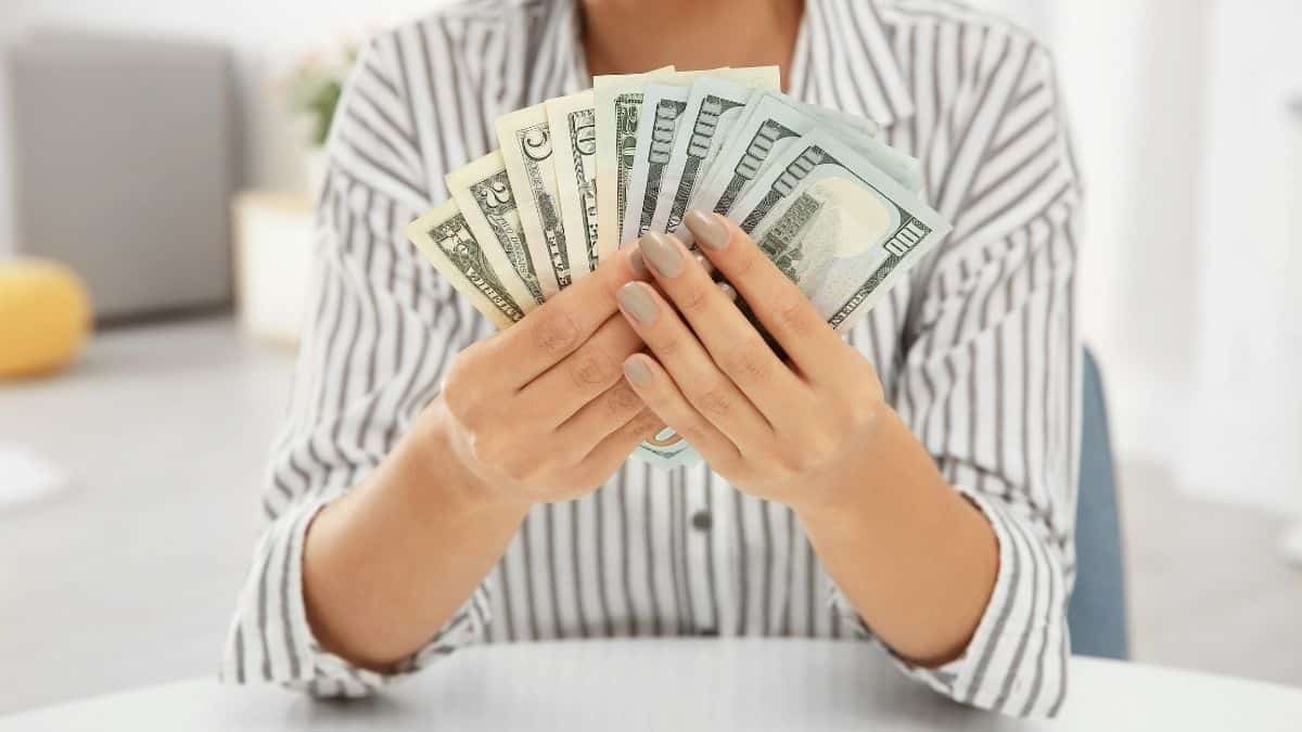 a woman holding a handful of cash.