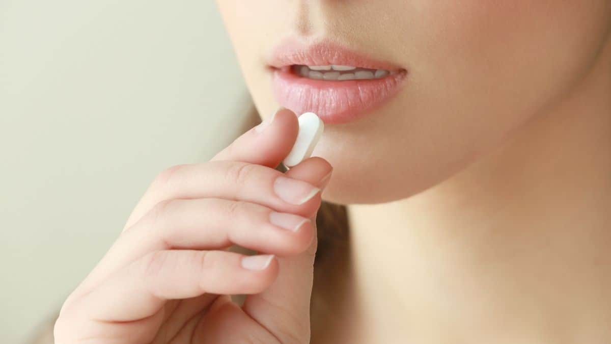 a woman taking a laxative pill because of her anorexia.