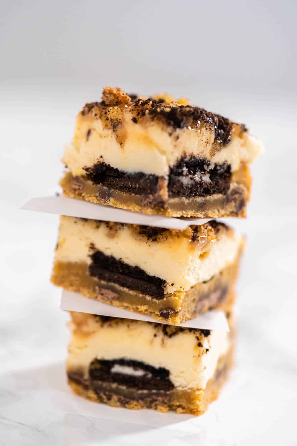 A stack of three slutty cheesecake bars.