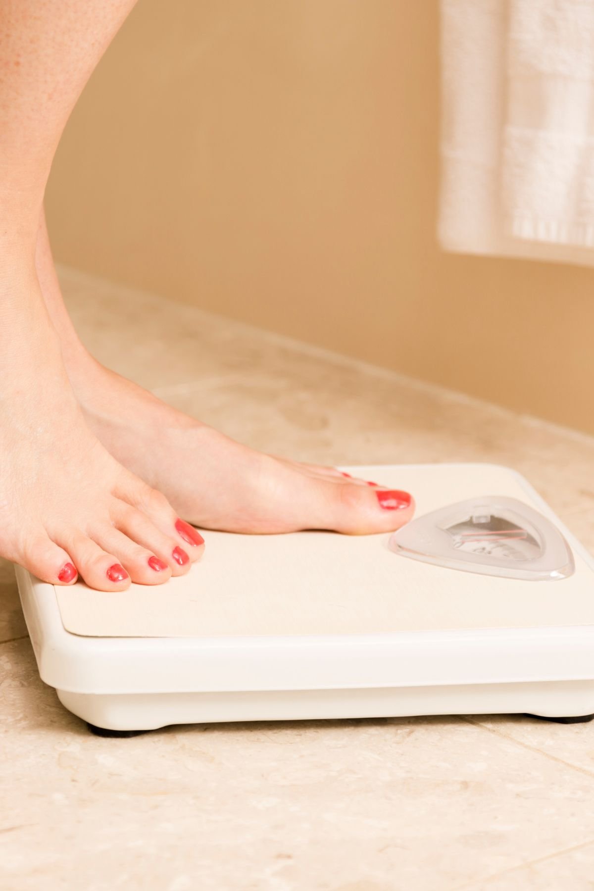 Stepping on a scale with fear of weight gain.