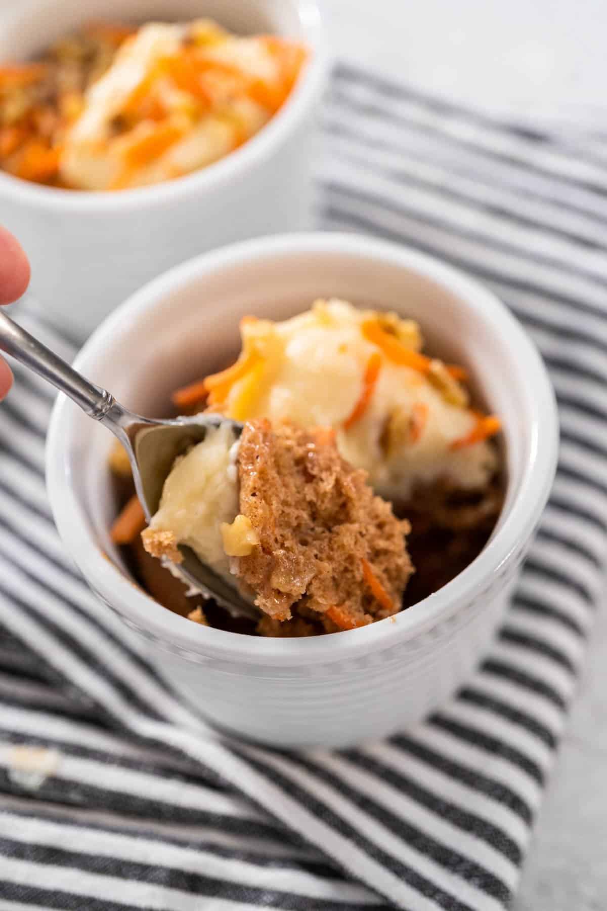 A spoonful of a single serve carrot cake served in a ramekin.