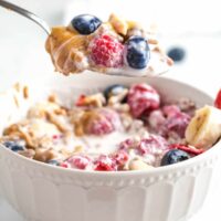 A spoonful of smoothie cereal with berries.