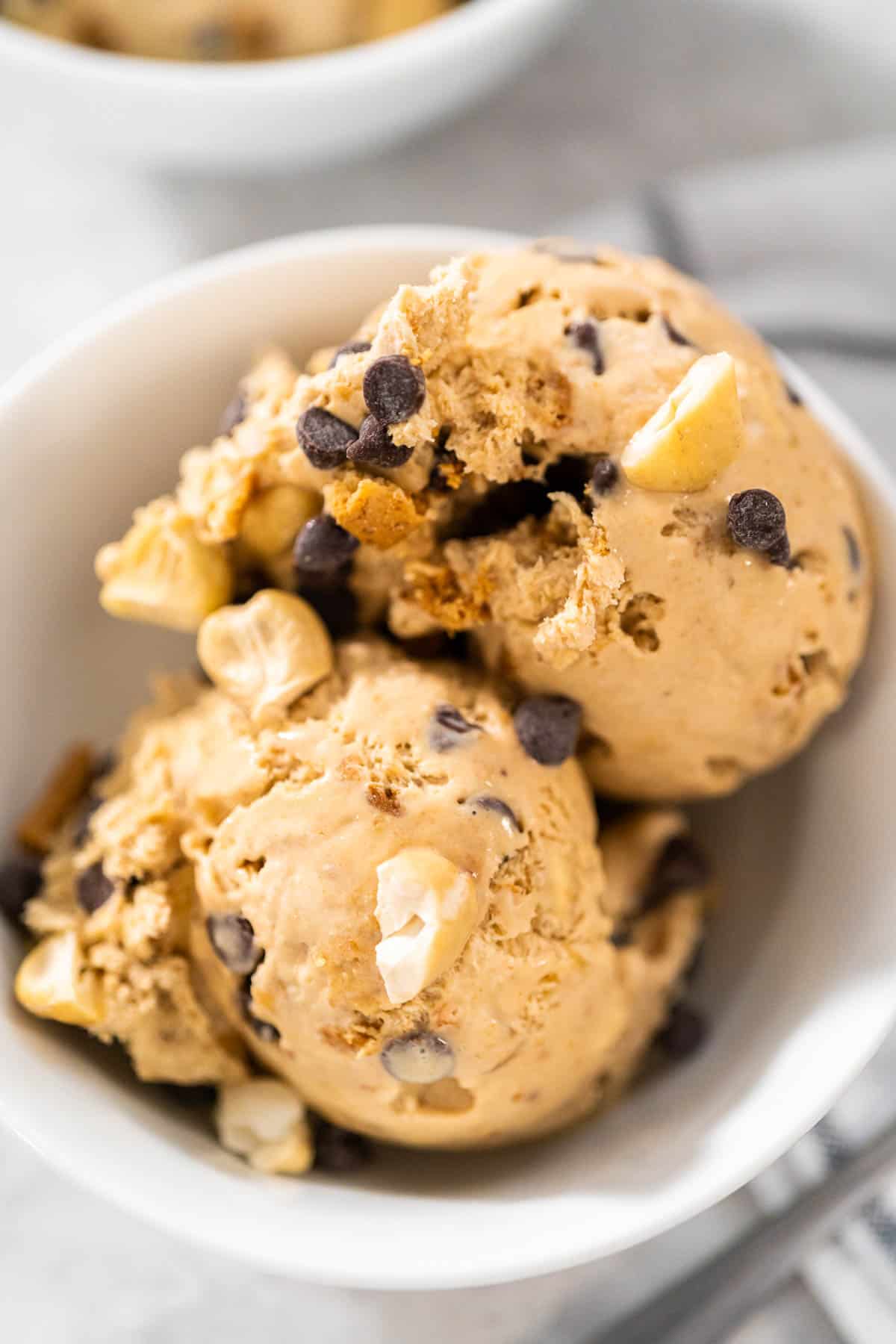 Two scoops of coffee ice cream in a white bowl.