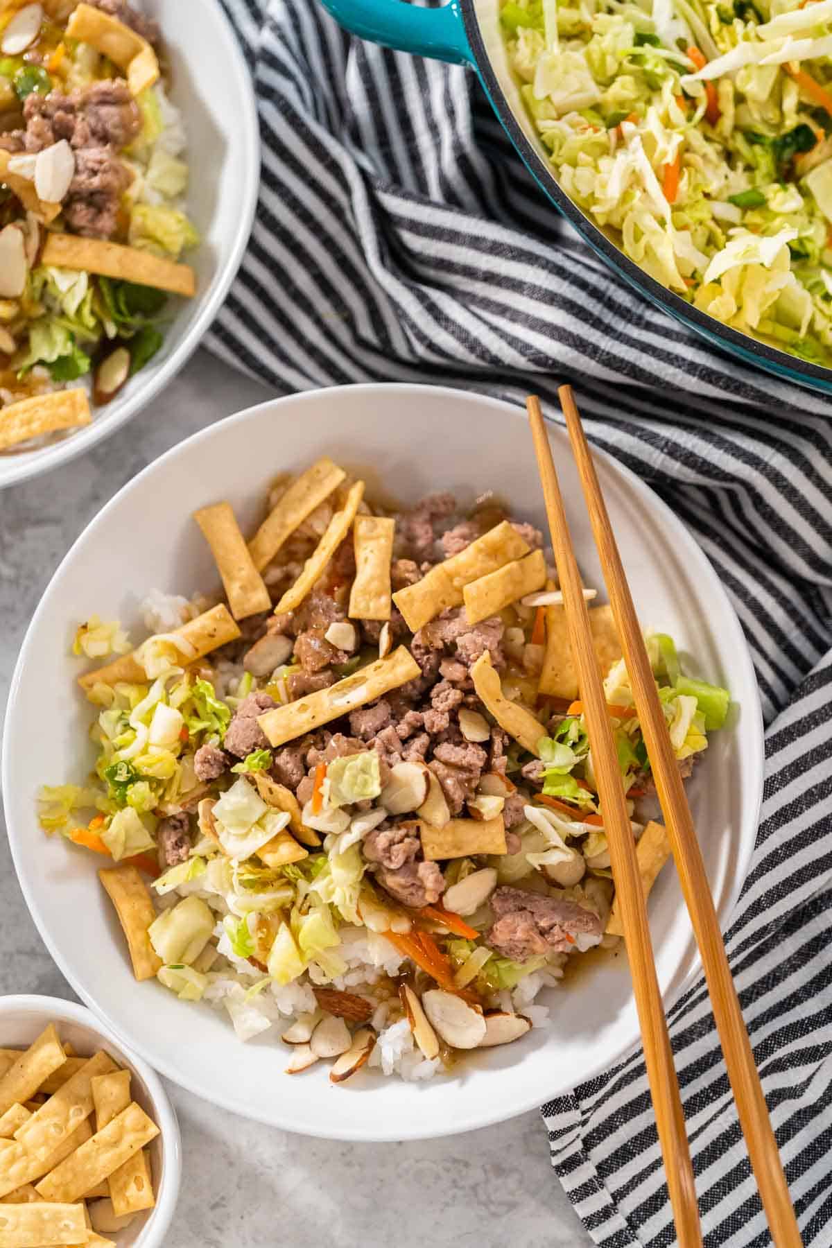 An overhead view of a bowl if stir fried Asian salad kit with coleslaw and topped with ground turkey.