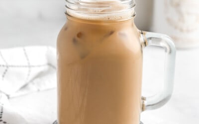A large glass mug filled with iced protein coffee.
