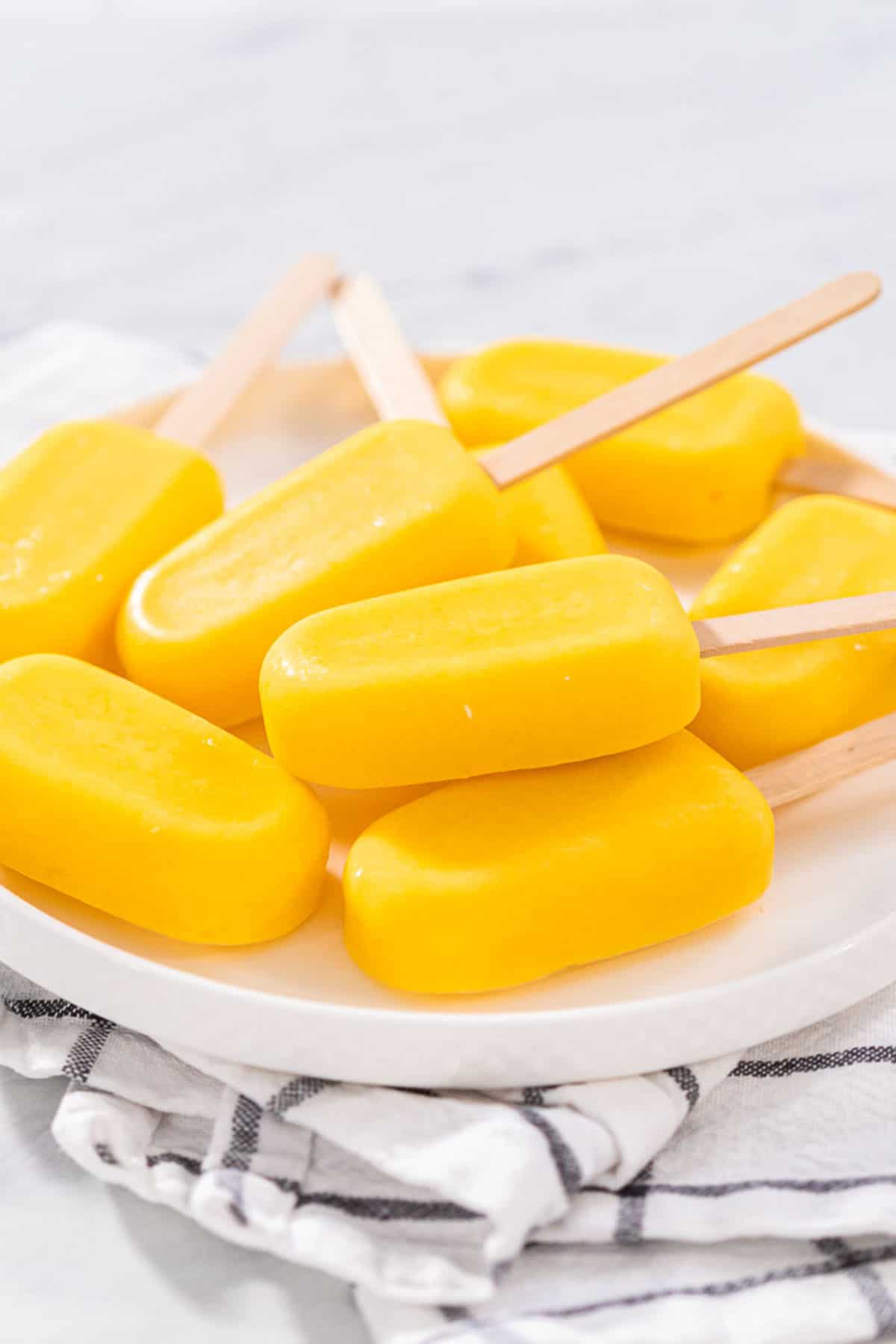 A white plate full of mango pops.