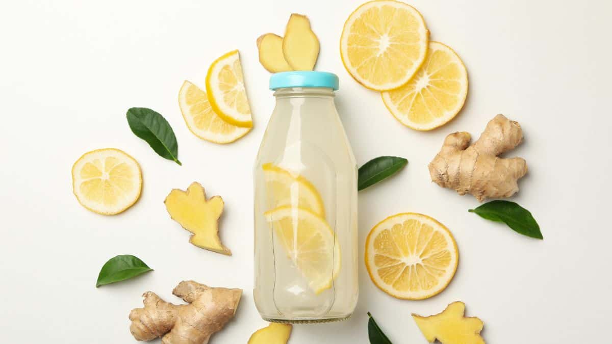 a bottle of lemon water with ginger surrounding it.