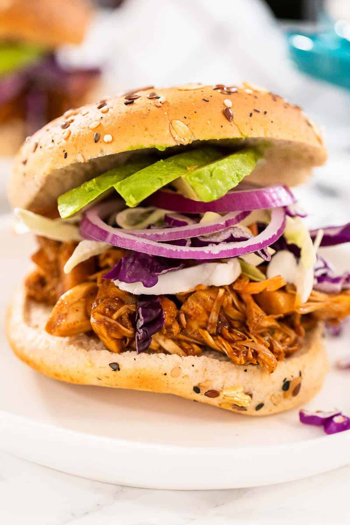 A stacked jackfruit burger, topped with a bun.