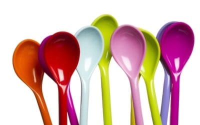 multi-colored spoons on white background.