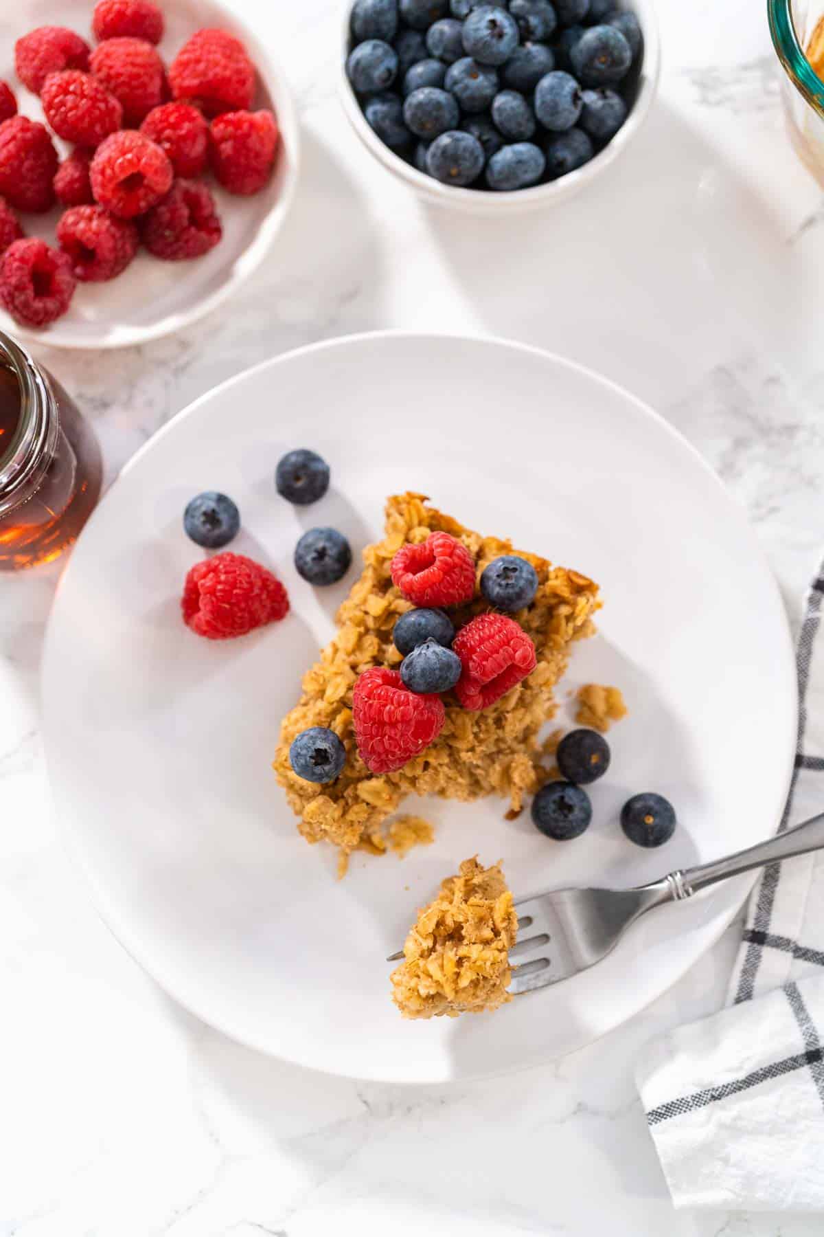 An overhead shot of baked oats without banana with fruit toppings on a white plate.