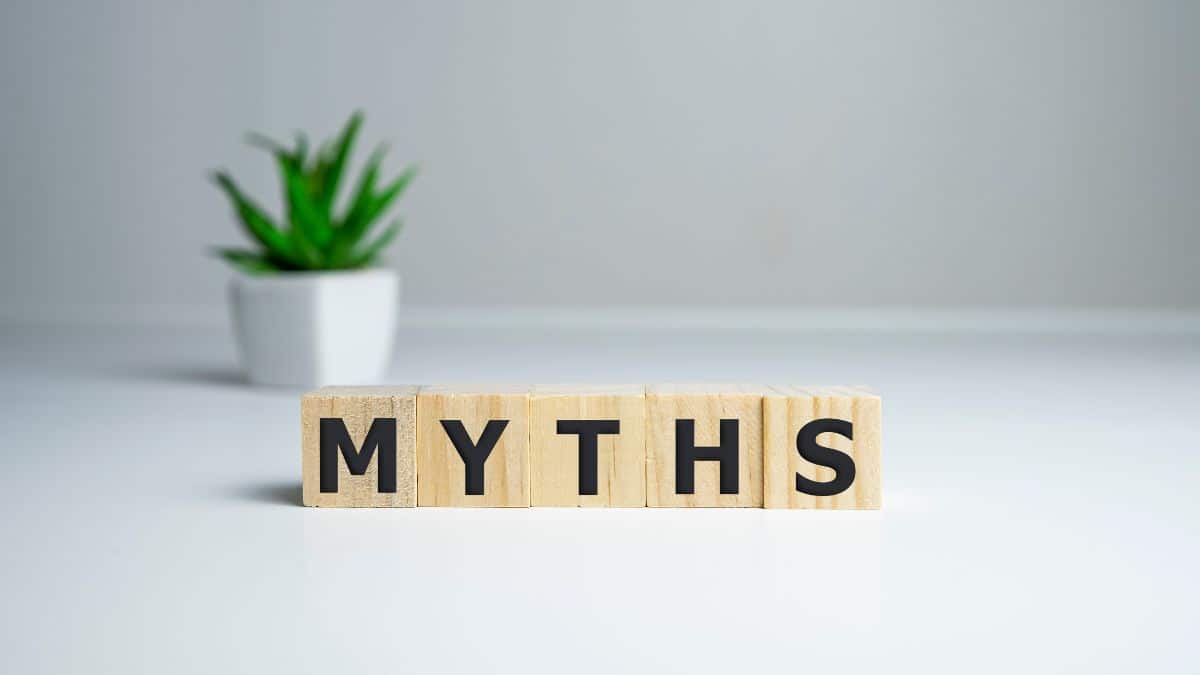 letter blocks spelling out myths” on a white background with a plant in the background.