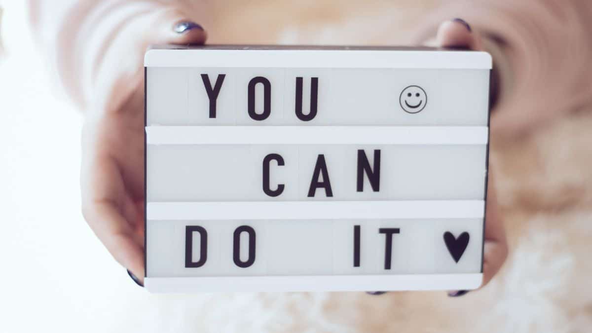 lady holding a sign board that says you can do it with a heart.