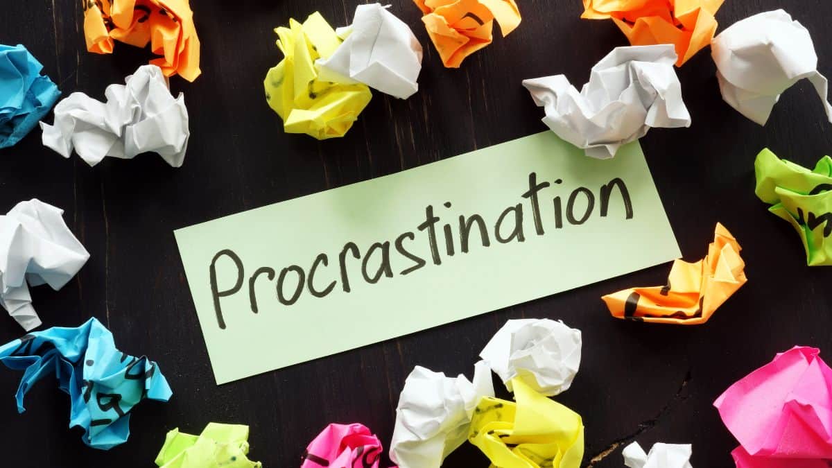the word procrastination in the middle of colorful crumpled paper.