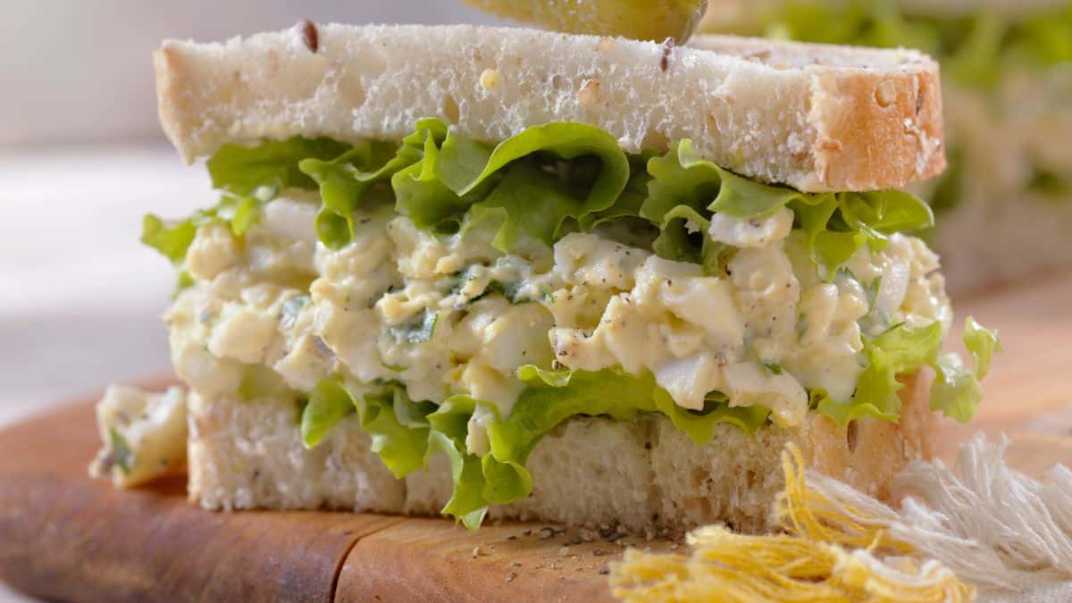 Fresh Egg salad sandwich on cutting board.