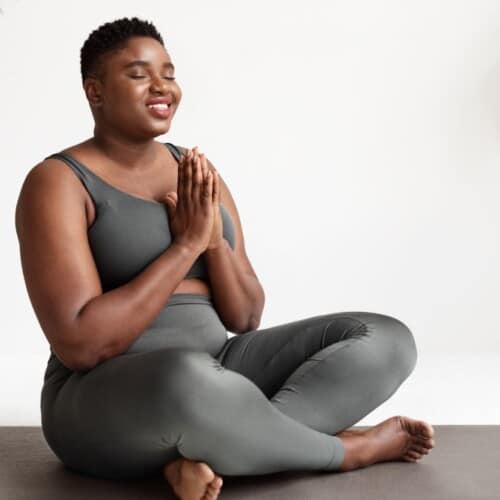 woman peacefully meditating with her hands in prayer position.