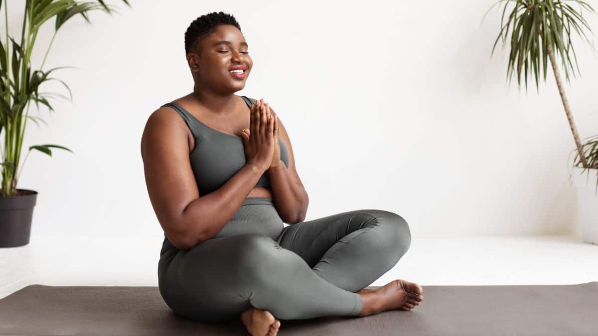 woman peacefully meditating with her hands in prayer position.